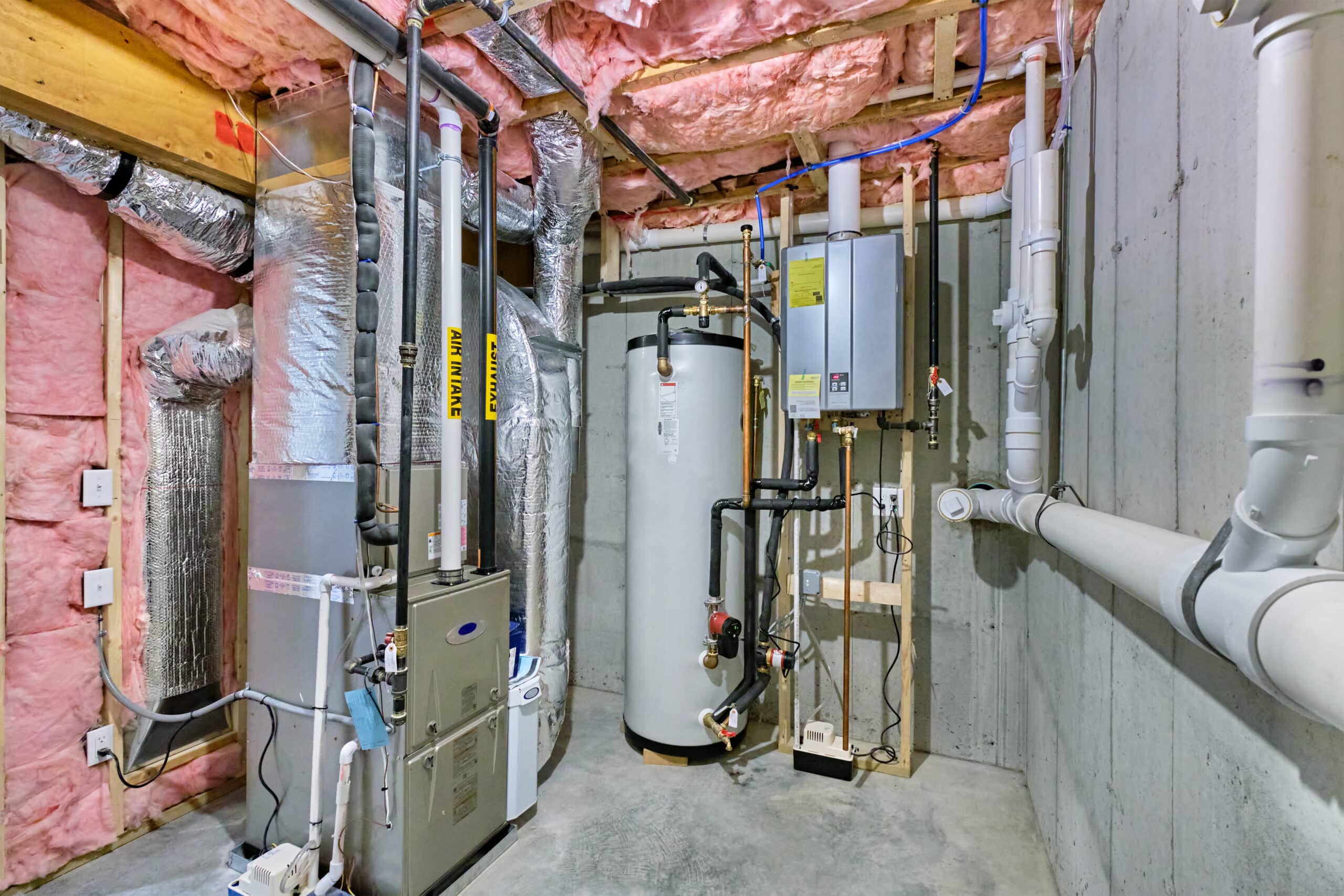 water_heater_ensor_blog_post Unfinished basement mechanical room with tankless water heater, storage tank, plumbing and heating systems